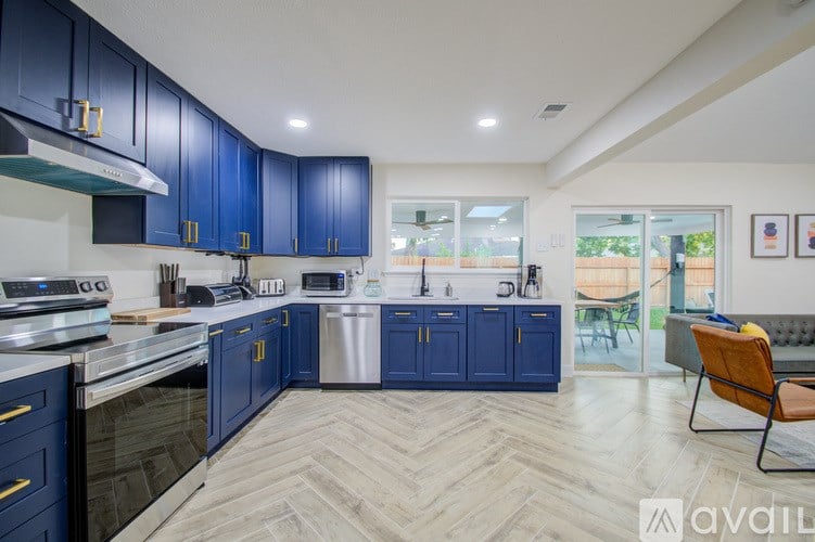 A kitchen with blue cabinets and a wooden floor.