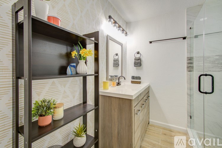 A bathroom with a shelf, a mirror, and a shower.