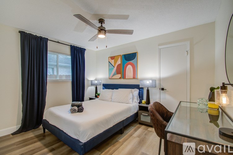 A bedroom with a bed, a chair, and a painting on the wall.