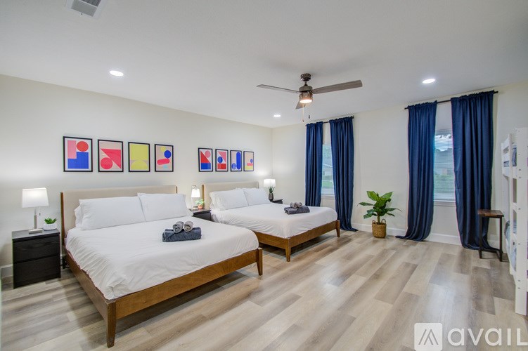 A bedroom with two beds and a ceiling fan.