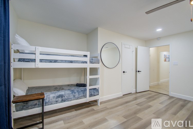 A bedroom with white walls and a bunk bed.