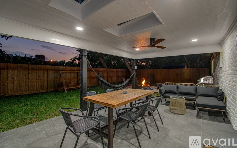 A patio with a table, chairs, and a fire pit.