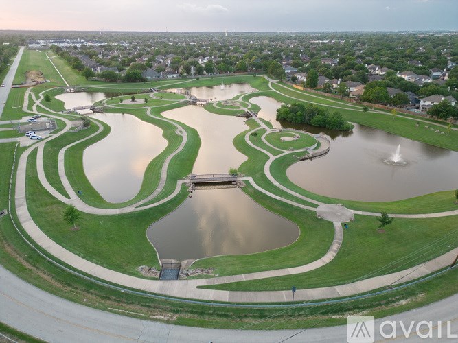 A large park with a pond and a bridge.