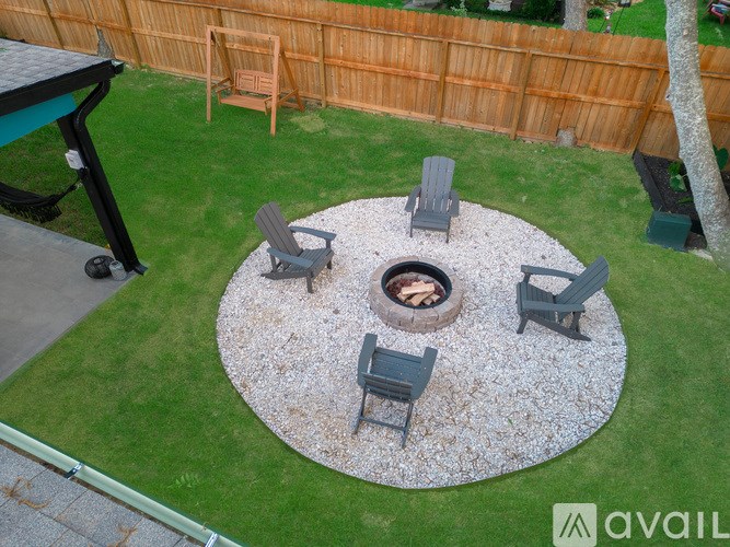 A fire pit surrounded by chairs in a backyard.