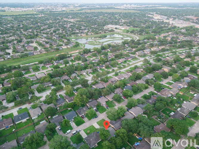 A bird's eye view of a residential area with a red pin marking a specific house.