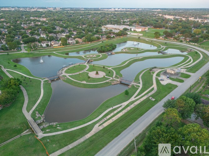 A large park with a lake and a bridge.