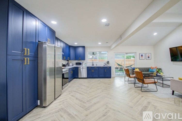 A kitchen with blue cabinets and a refrigerator.