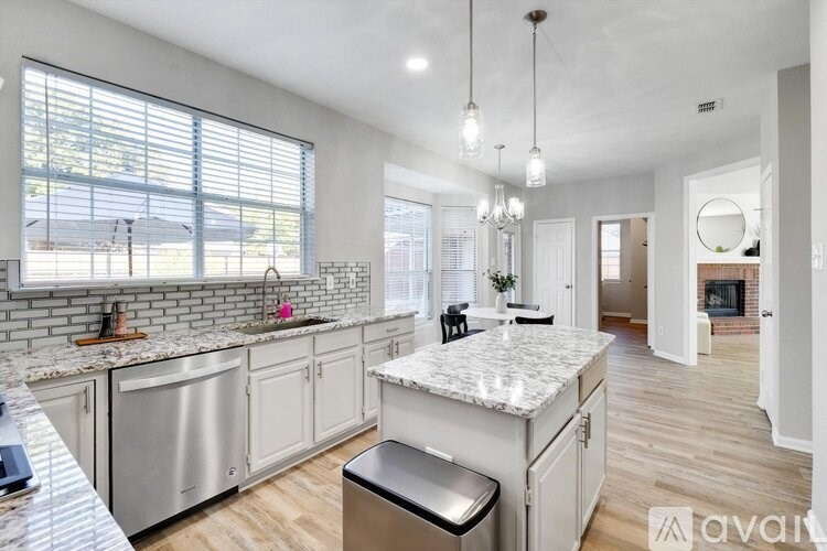 A kitchen with a marble countertop and stainless steel appliances.