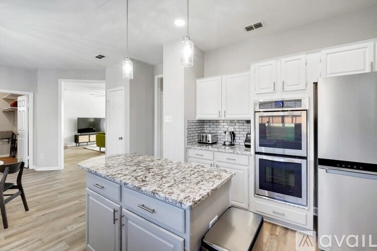 A kitchen with a granite countertop and stainless steel appliances.