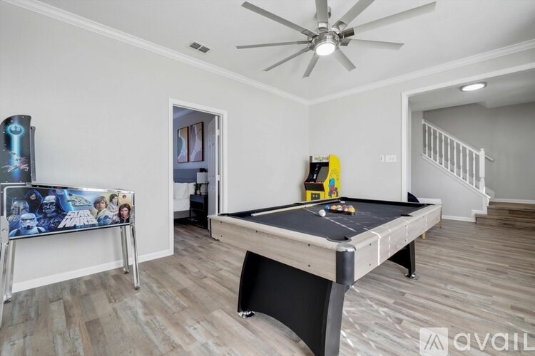 A room with a pool table and a ceiling fan.