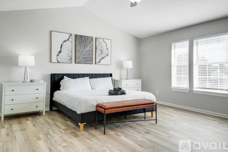 A bedroom with a bed, nightstand, and two lamps.