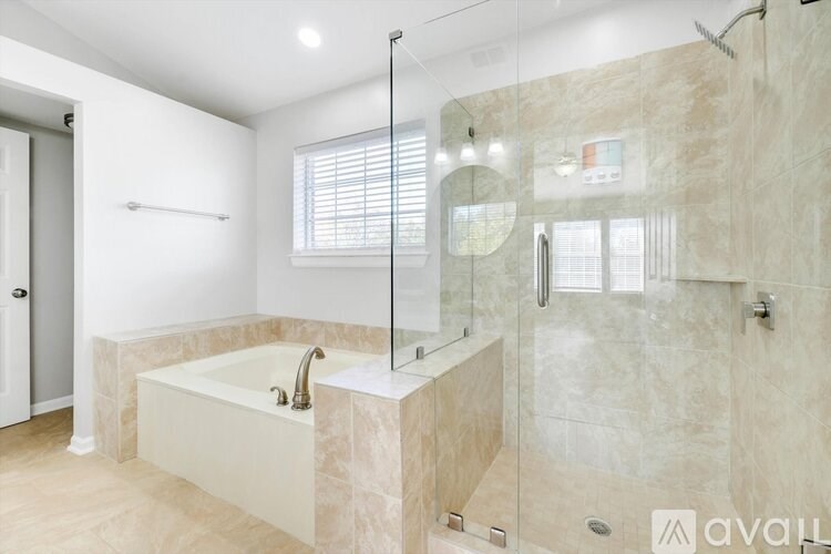 A bathroom with a white tub and a walk-in shower.