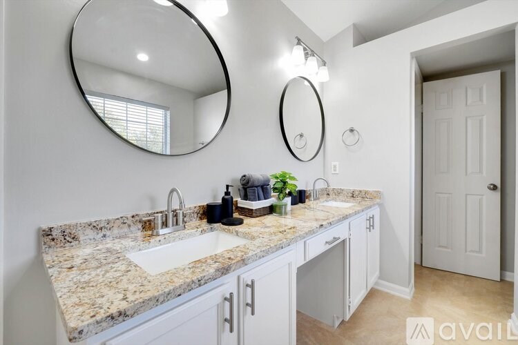 A bathroom with a marble countertop and two sinks.