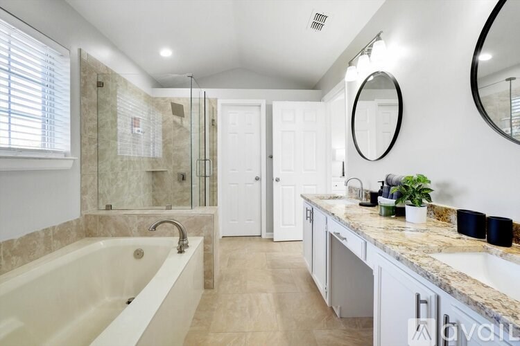 A bathroom with a tub, sink, mirror, and shower.