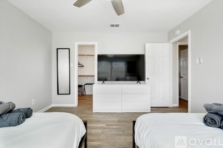 A bedroom with two beds and a television in the corner.