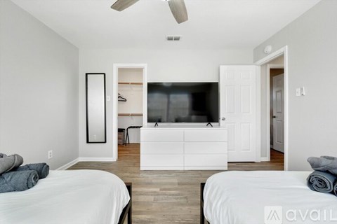 A bedroom with two beds and a television in the corner.