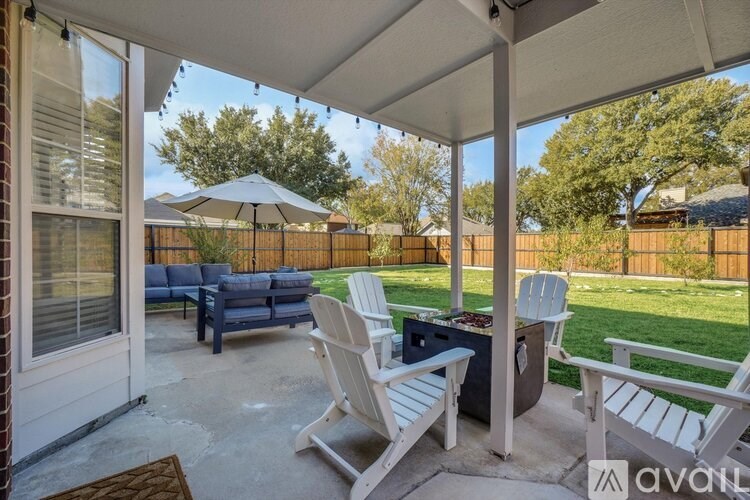 A patio with a table and chairs under a white canopy.