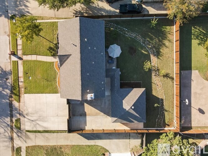 A modern house with a large driveway and a small garden.