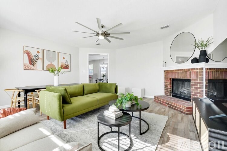 A living room with a green sofa and a fireplace.