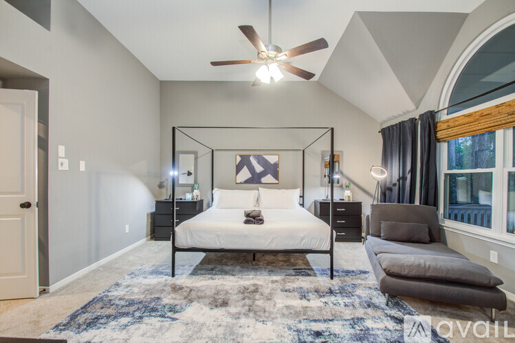 A bedroom with a four poster bed and a rug on the floor.