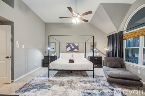 A bedroom with a four poster bed and a rug on the floor.