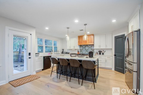 A kitchen with a table and chairs in the middle of it.