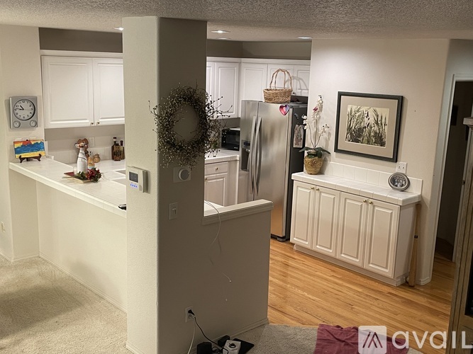 A kitchen with white cabinets and a wooden floor.
