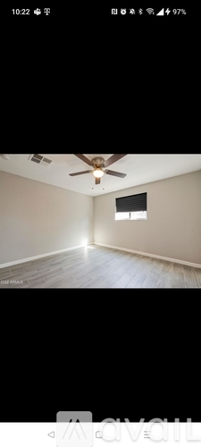 A room with a ceiling fan and a window.