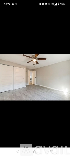 A room with a ceiling fan and wooden flooring.