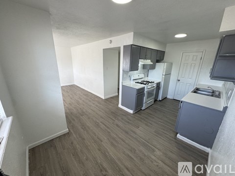 A kitchen with a stove top oven and a refrigerator.