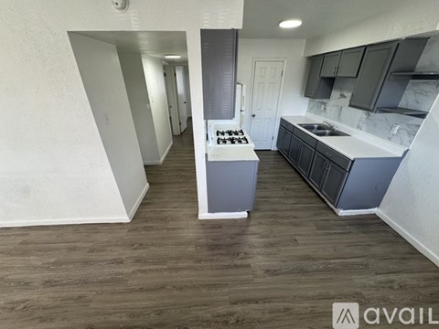 A kitchen with a white countertop and a wooden floor.