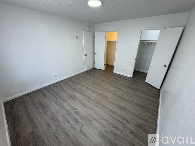 A room with a wooden floor and white walls.