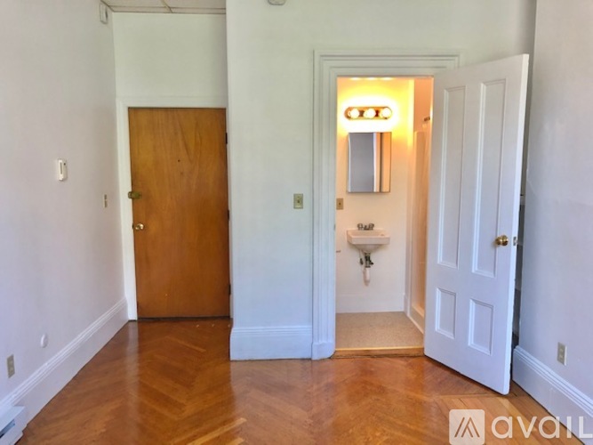A room with a wooden door and a white door with a mirror above it.