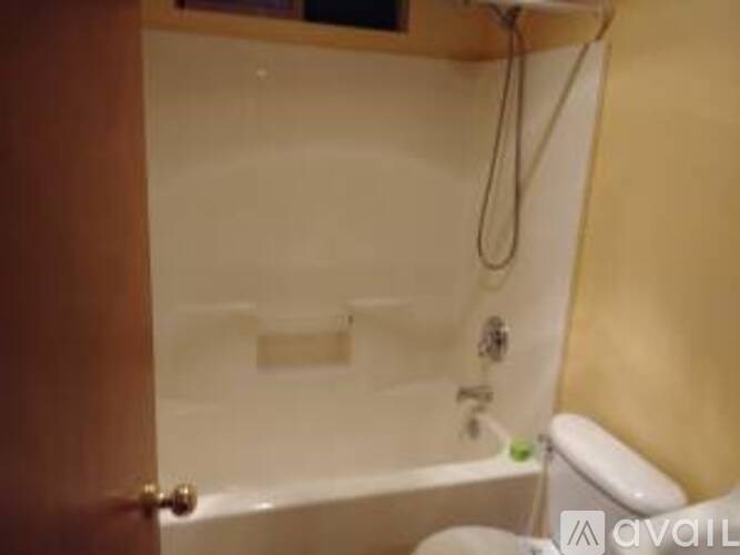 A bathroom with a tub and a toilet.