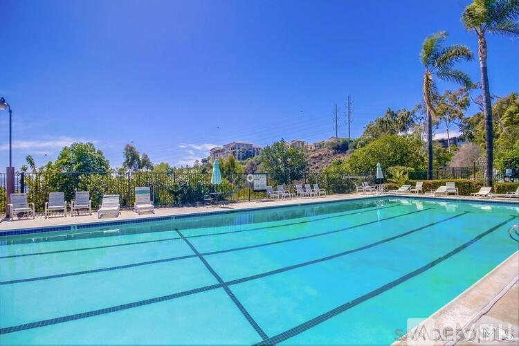 A large swimming pool surrounded by palm trees and lounge chairs.