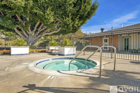A pool surrounded by a fence with a tree in the background.