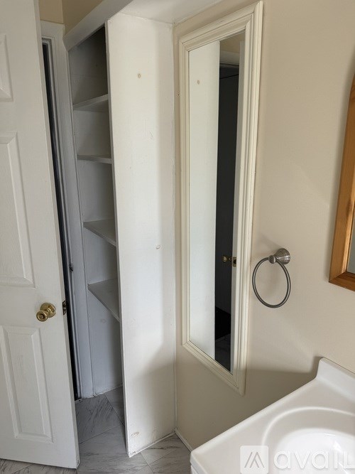 A white door is open to a dark room.