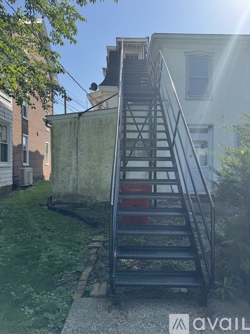 A metal staircase with a railing is in front of a building.