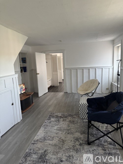 A living room with a chair and a rug.