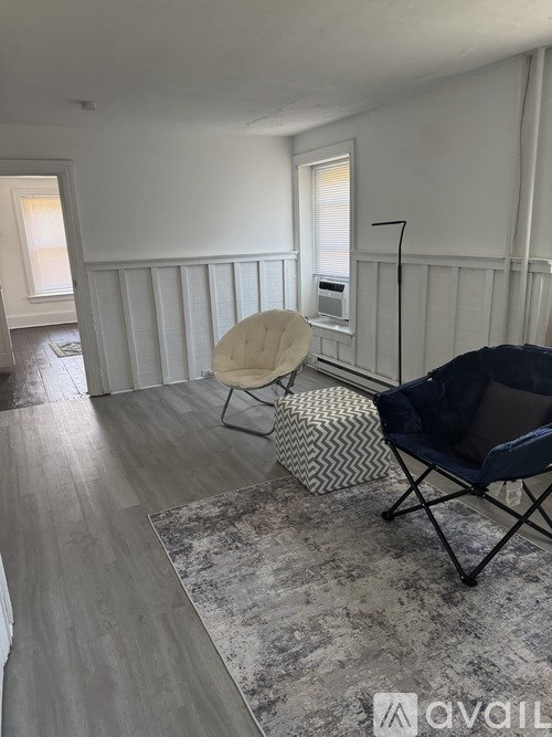 A room with a chair and a rug in it.