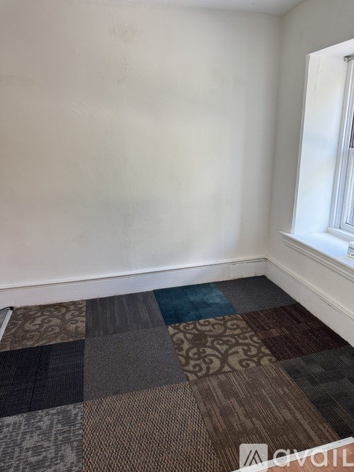 A room with a carpeted floor and a window.