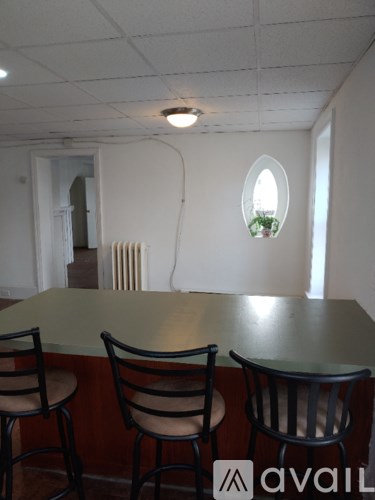 A kitchen with a table and chairs and a window.