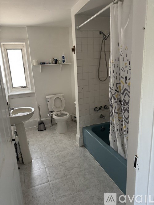 A bathroom with a toilet, sink, and bathtub.