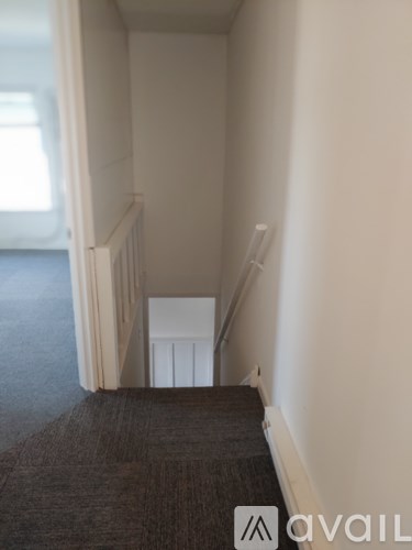 A stairway with a carpeted floor and white railings.