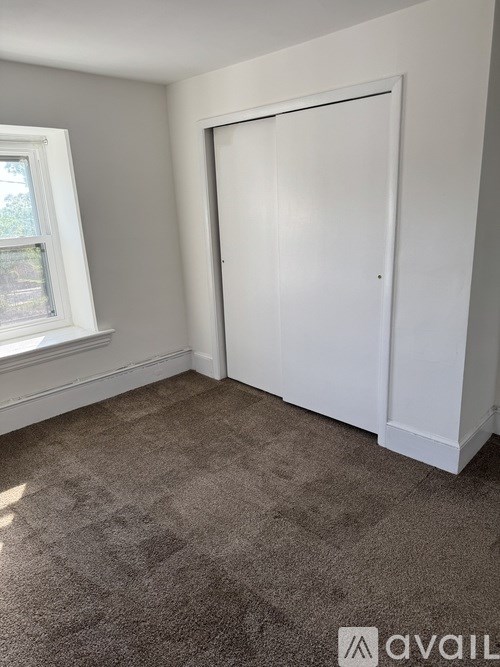 A room with a carpeted floor and a white door.