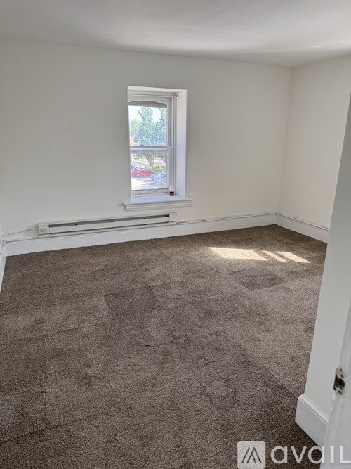 A room with a carpeted floor and a window.