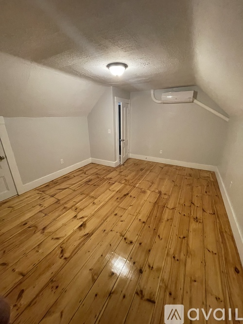 A room with wooden flooring and a white ceiling.