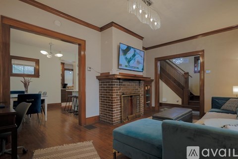 A living room with a fireplace and a television on the wall.