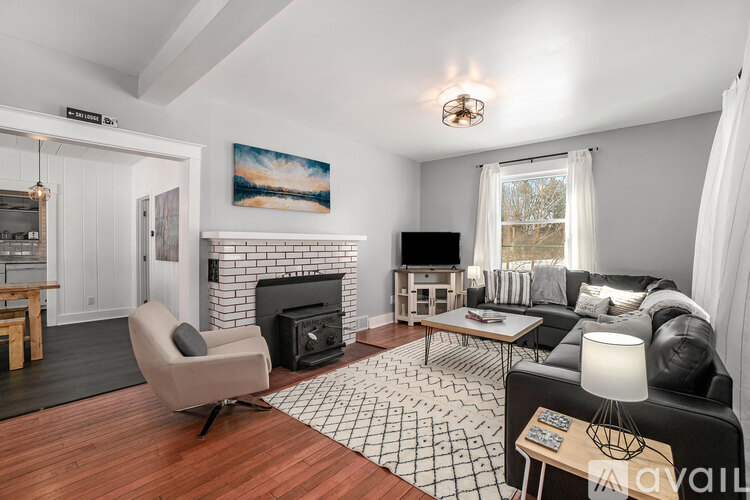 A living room with a fireplace and a painting on the wall.