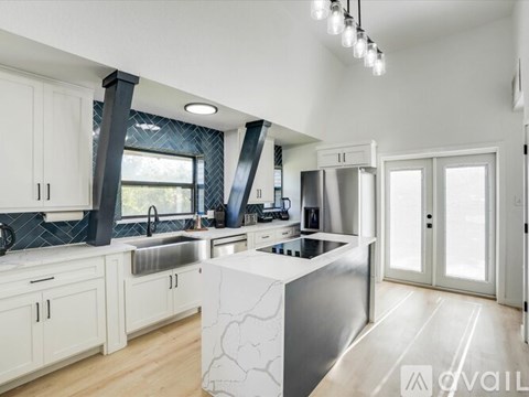 A modern kitchen with white cabinets and a central island.
